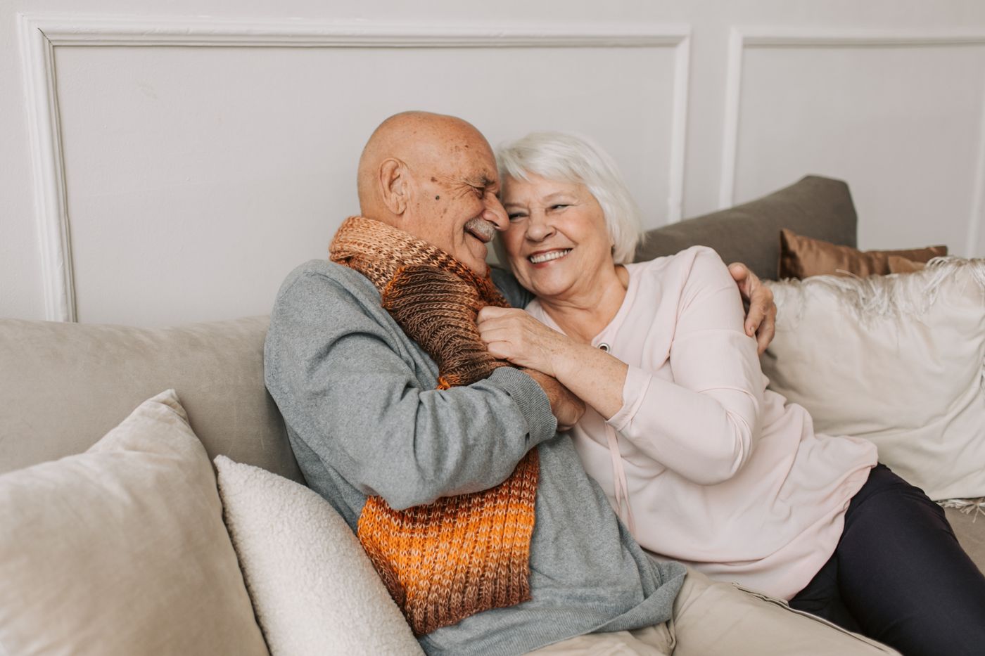An older couple laughing together at home